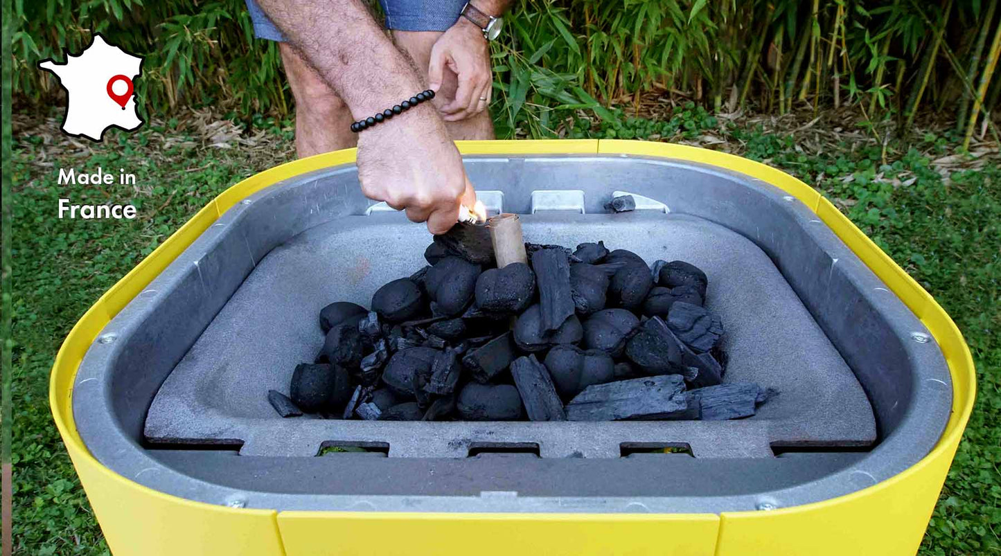 Personne allumant un allume MARCEL et charbon de bois forme coeur écoresponsable avec symbole made in france