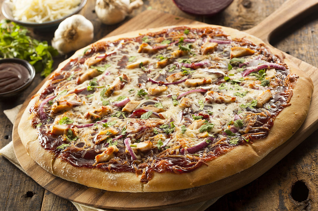 Pizza cuite au barbecue sur pelle à pizza en bois avec oignon, ail et herbes