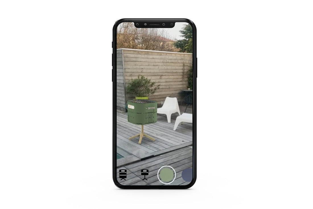 Téléphone mobile avec filtre instagram et facebook en réalité augmentée pour choisir un barbecue adapté aux attentes - barbecue charbon marcel vert réséda sur terrasse en bois